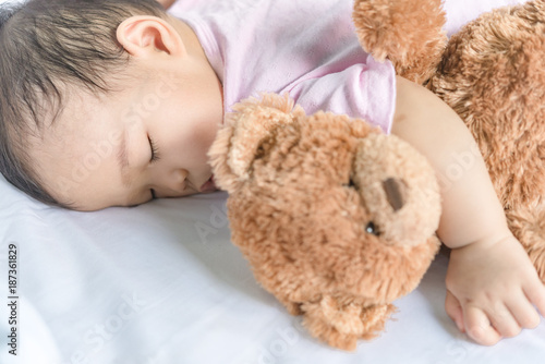 Asian baby sleeping on the bed,thailand people,relax time,bear doll