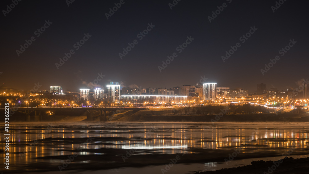 Evening view of city Ufa over White River covered with ice at winter, Russia.