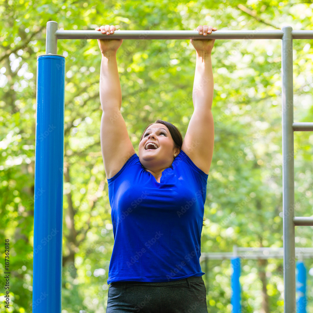 Plump young woman making sport exercises at high bar Plump young woman making sport exercises at high bar