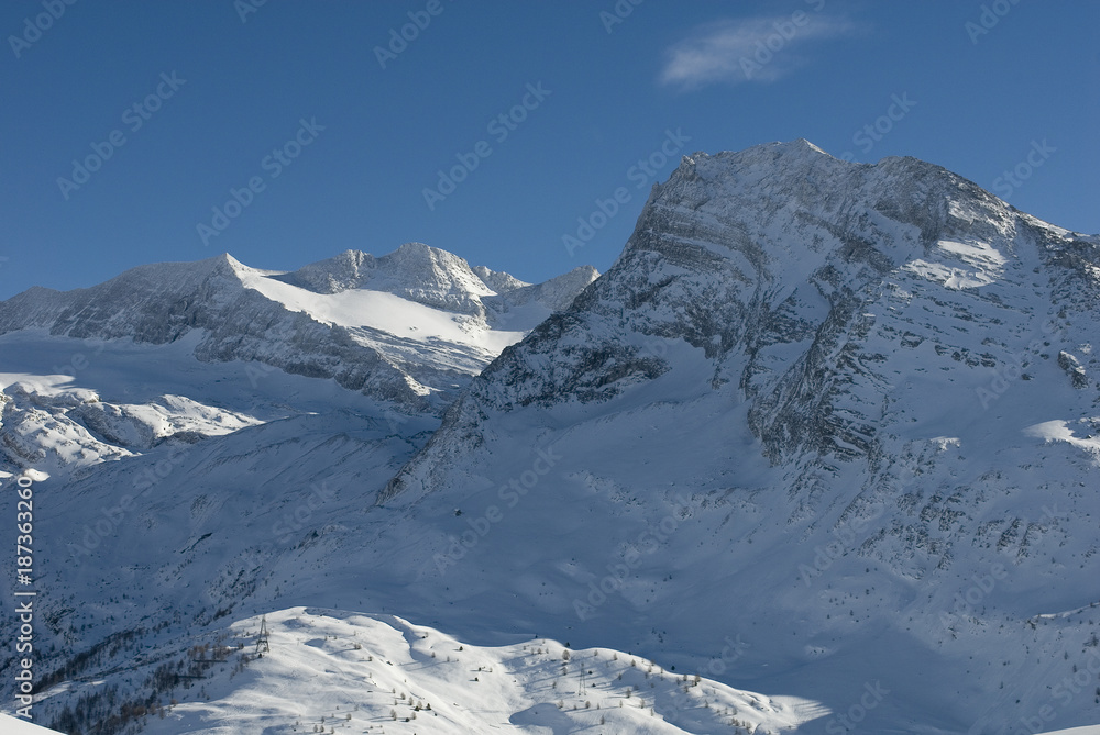 high mountain landscape, photo from mountain summit, on sunny day, blue sky, after a snowfall, in the background the glacier of Mount Breithorn, Simplon Pass, Alps, winter, cold, Valais, Switzerland high mountain landscape, photo from mountain summit, on sunny day, blue sky, after a snowfall, in the background the glacier of Mount Breithorn, Simplon Pass, Alps, winter, cold, Valais, Switzerland