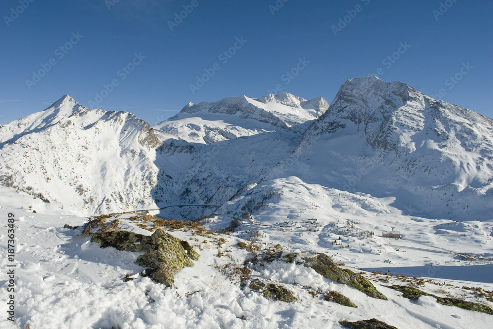 high mountain landscape, photo take from mountain summit, on sunny day, blue sky, after a snowfall, in background the glacier of Mount Breithorn, Simplon Pass, Alps, winter, cold, Valais, Switzerland