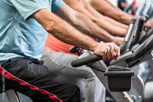 Group of people spinning at the gym on fitness bikes