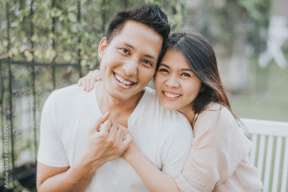 Happy Asian couple in love smiling and having fun while hugging outdoor. Happy Asian couple in love smiling and having fun while hugging outdoor.
