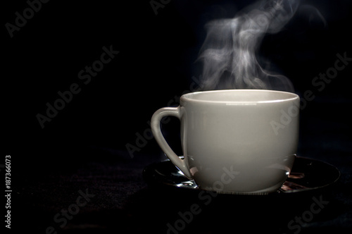 Moody White porcelain Coffee tea mug cup isolated on black background, with soft white steam smoke from fresh brewed coffee