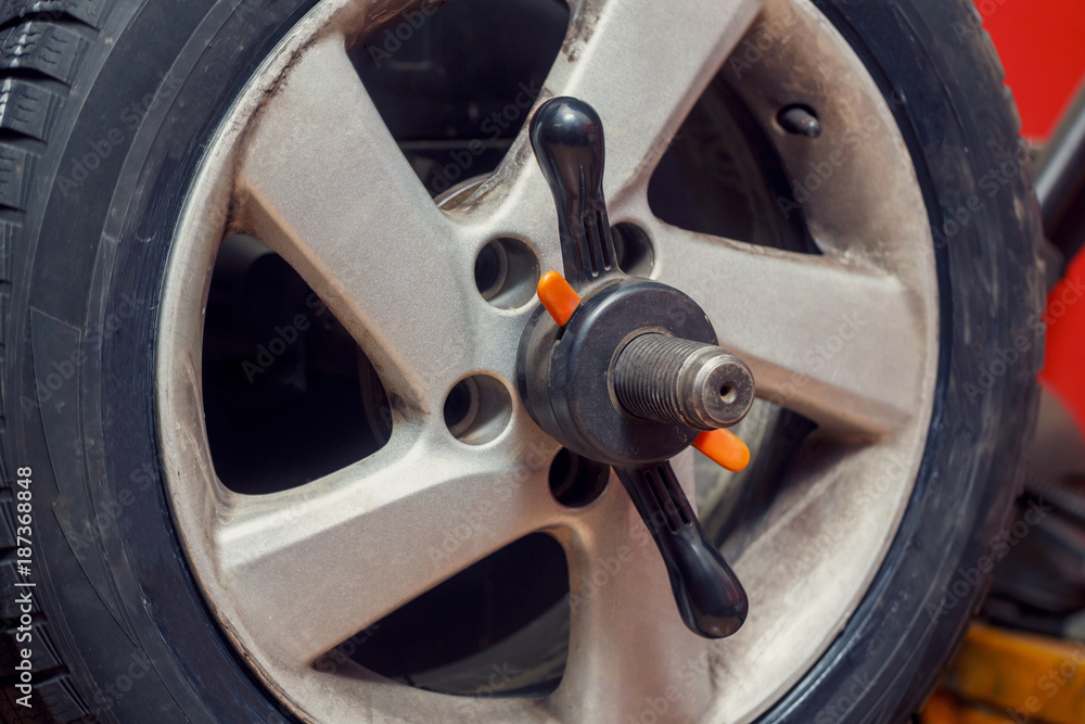 Technician work with mechanic balancing wheel. Installing wheel process. Technician work with mechanic balancing wheel. Installing wheel process.