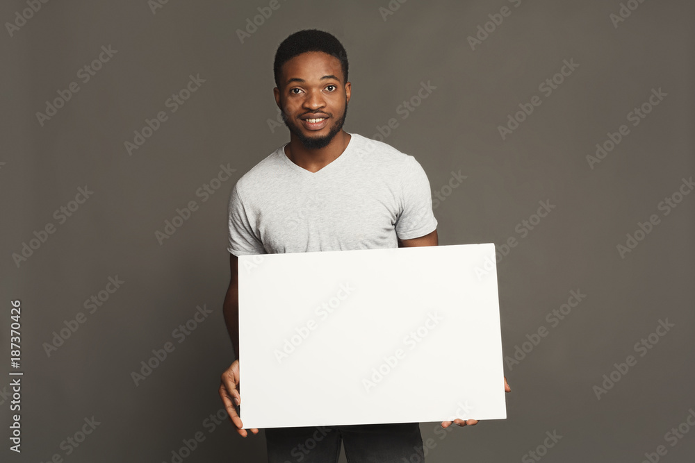 Picture of young african-american man holding white blank board Picture of young african-american man holding white blank board