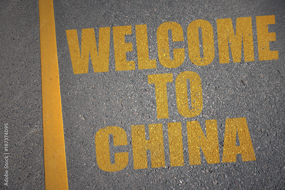 asphalt road with text welcome to china near yellow line.