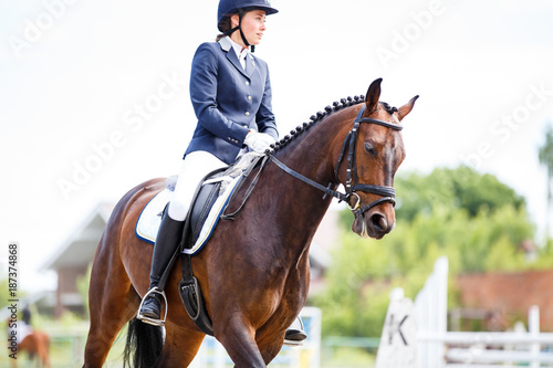Young rider woman on her course in dressage competition advanced test