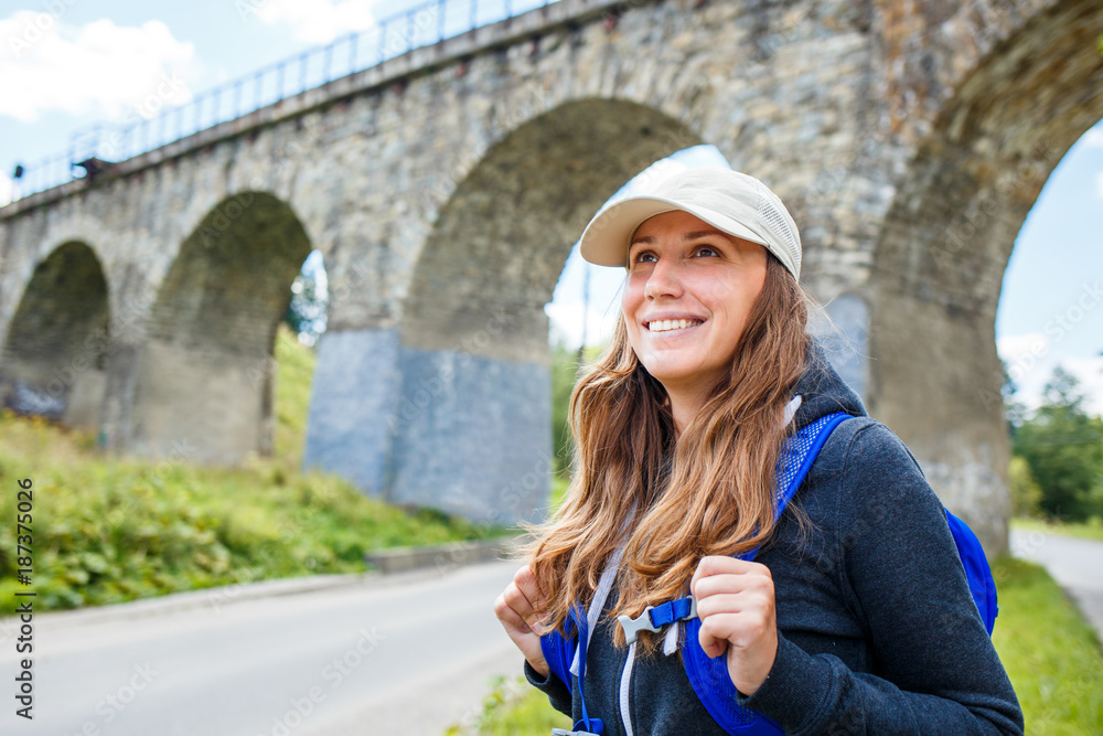 Young happy woman traveling with backpack in europe countryside. Travel concept image with copy space