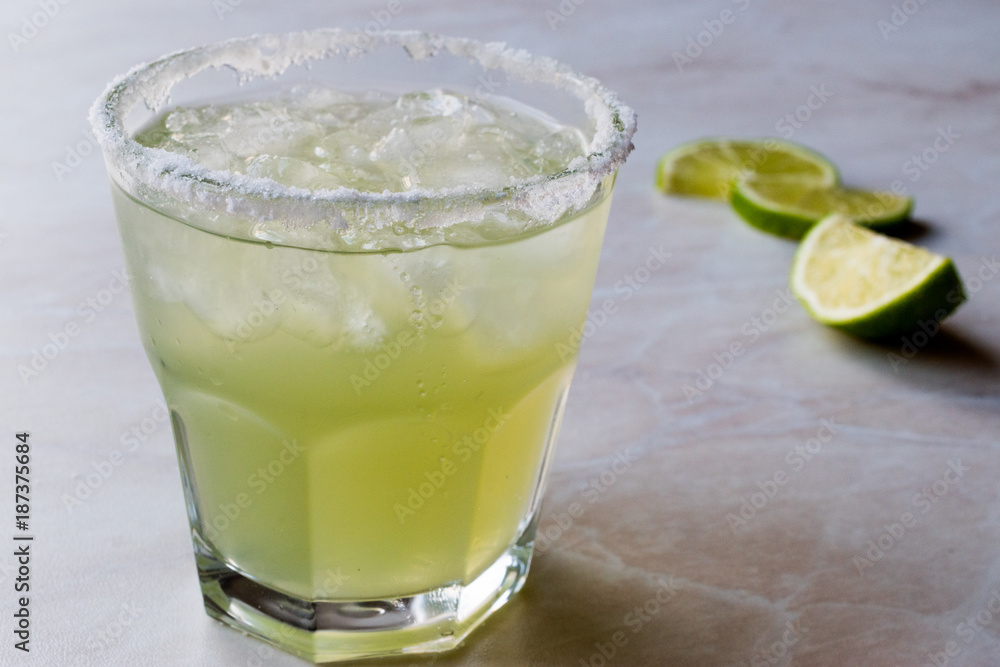Classic Margarita Cocktail in Salted Glass with Lime and Crushed ice. Classic Margarita Cocktail in Salted Glass with Lime and Crushed ice.