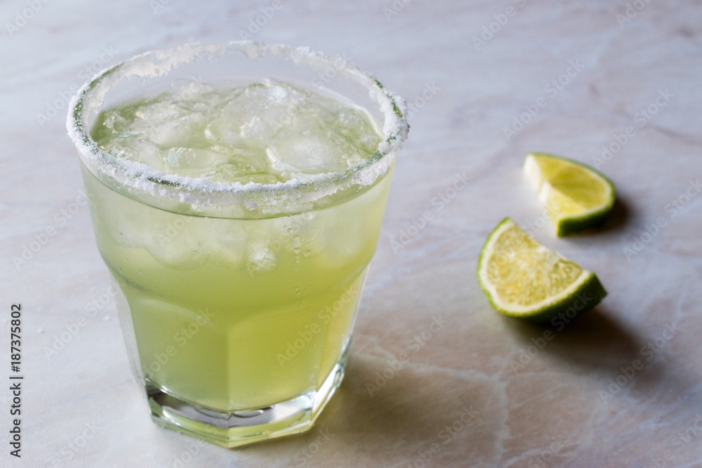 Classic Margarita Cocktail in Salted Glass with Lime and Crushed ice. Classic Margarita Cocktail in Salted Glass with Lime and Crushed ice.