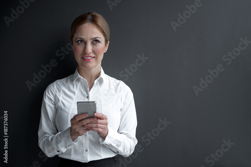 What should I write. Portrait of pensive female noting in mobile. Profession and technology concept