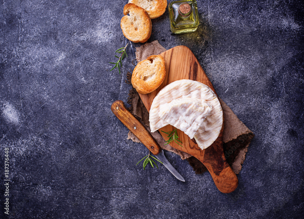 Camembert cheese with rosemary on wooden board Camembert cheese with rosemary on wooden board