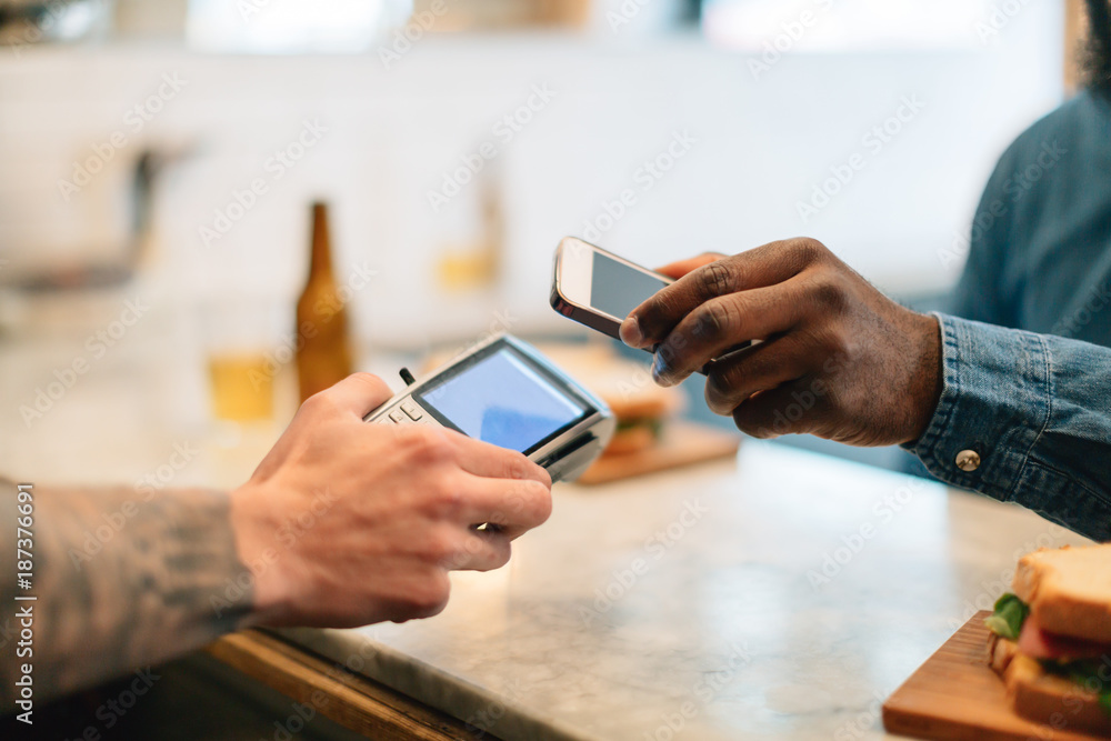 Customer paying with her mobile phone at a restaurant. Customer paying with her mobile phone at a restaurant.