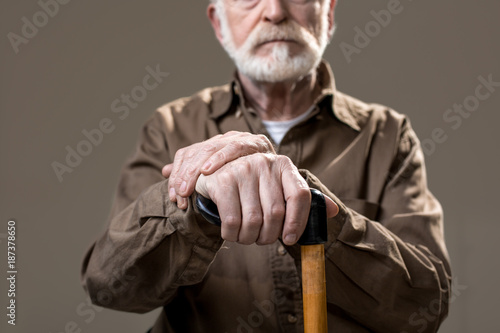 Slika na platnu Bearded old man with arms resting on walking cane