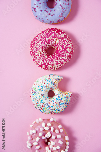Various donuts line on a pink background. Sweetness happiness conception. 