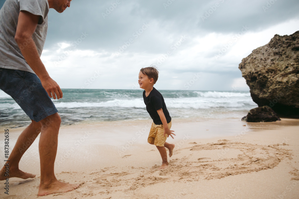 Fun loving dad playing with kids during vacation on beach Fun loving dad playing with kids during vacation on beach