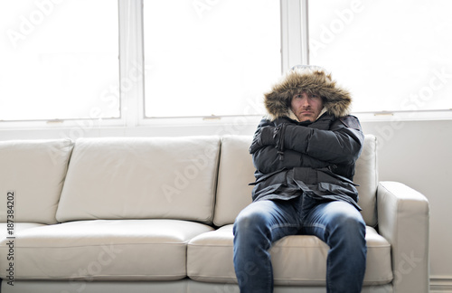 Photo Man With Warm Clothing Feeling The Cold Inside House on the sofa