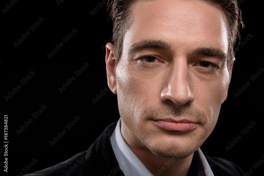 Top manager. Close-up of face of confident serious businessman is looking at camera single-mindedly. Isolated on black background Top manager. Close-up of face of confident serious businessman is looking at camera single-mindedly. Isolated on black background