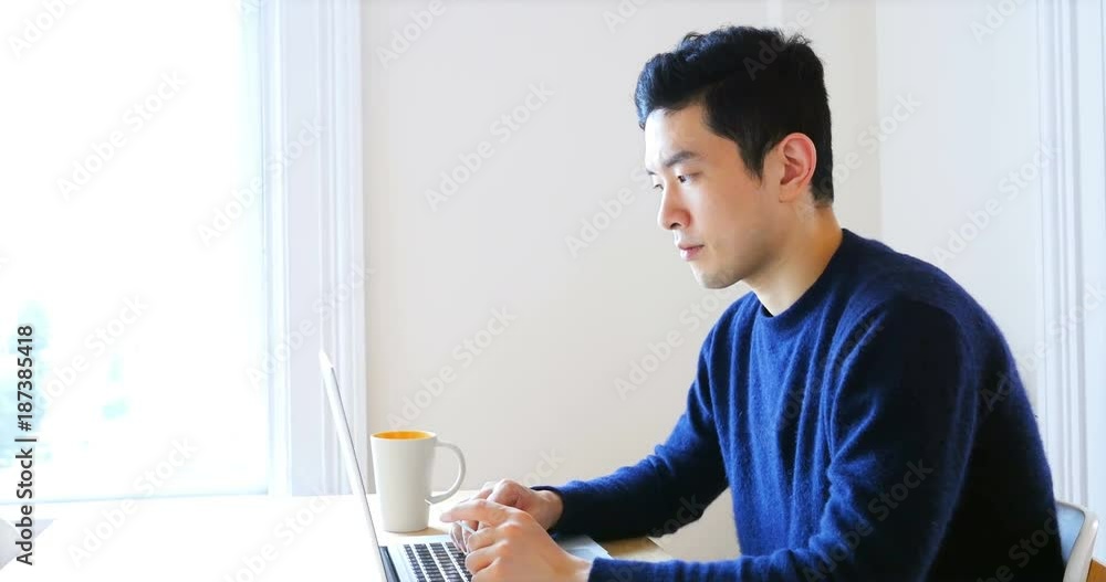 Man using laptop while having cup of coffee Man using laptop while having cup of coffee