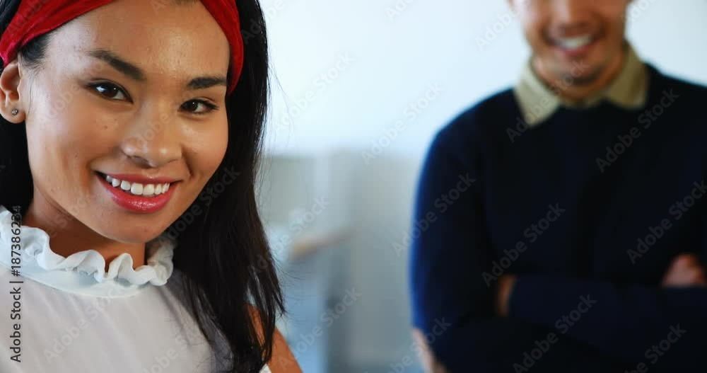 Smiling female and male executives standing in office Smiling female and male executives standing in office