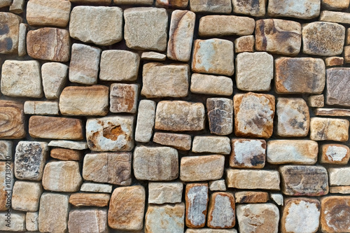 Detail of stone wall made from rounded square rocks.