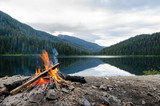 Landscape of a campfire in a peaceful lake valley.