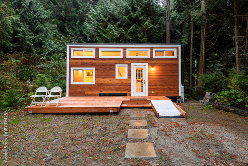 Billede på lærred Small wooden cabin house in the evening. Exterior design.