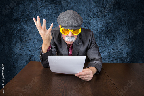 Senior sitzt am Tisch studiert Rechnung und fühlt sich betrogen