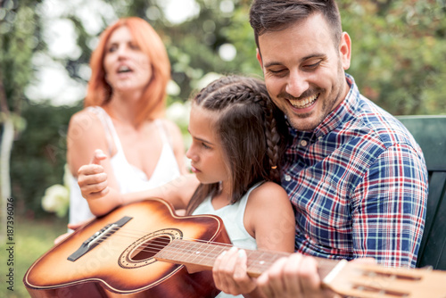 Happy family playing the guitar together