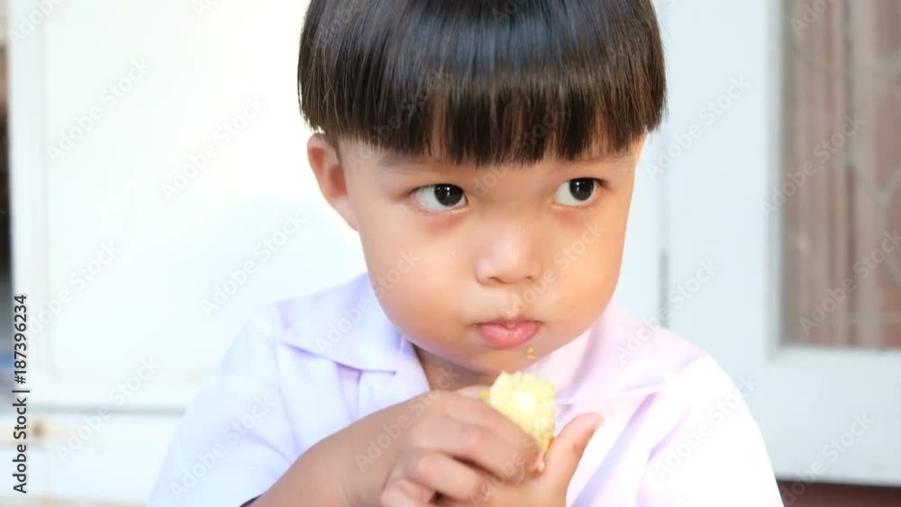 Little boy eating corn and looking for something Little boy eating corn and looking for something