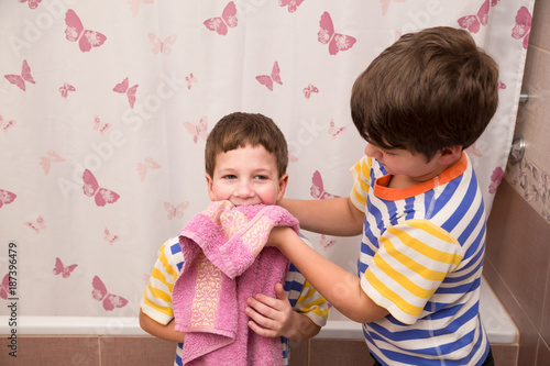 Vászonkép Older brother wipe his younger brother in the bathroom