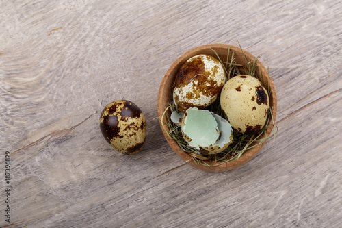 Quail eggs and eggshell on a wooden background.