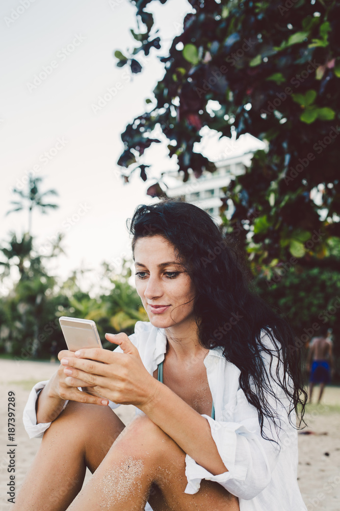 Woman using mobile phone on the beach Woman using mobile phone on the beach