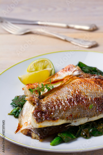 Dorado or dorada fish fillet with spinach, thyme and lime, vertical