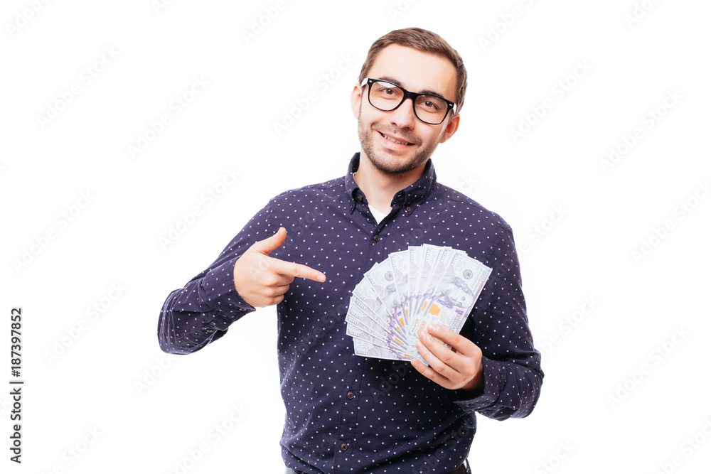 Portrait of a smiling successful man in suit and eyewear pointing finger at a bunch of money banknotes isolated over white Portrait of a smiling successful man in suit and eyewear pointing finger at a bunch of money banknotes isolated over white