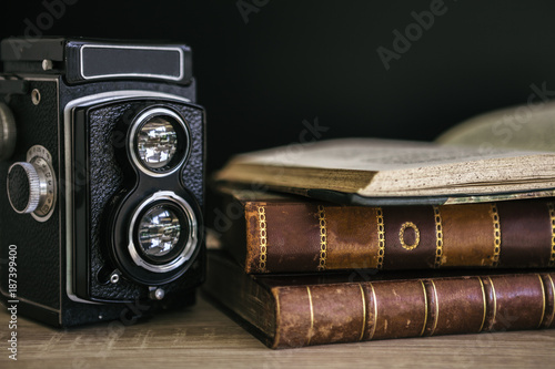Close-up of old camera and stack of books