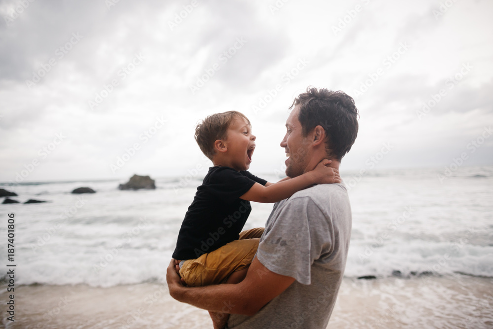 Fun loving dad playing with kids during vacation on beach Fun loving dad playing with kids during vacation on beach