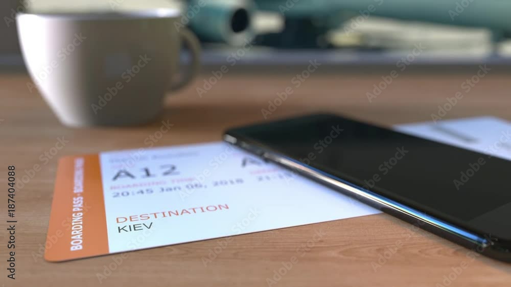 Boarding pass to Kiev and smartphone on the table in airport. Travelling to Ukraine conceptual animation Boarding pass to Kiev and smartphone on the table in airport. Travelling to Ukraine conceptual animation