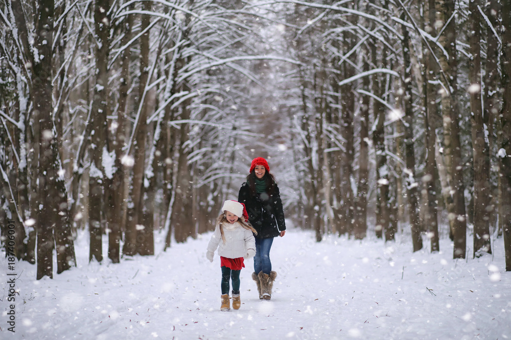 A winter fairy tale, a young mother and her daughter ride a sled