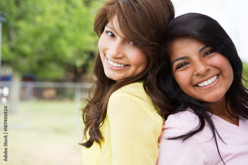 Obraz premium Sisters laughing and having fun outside.