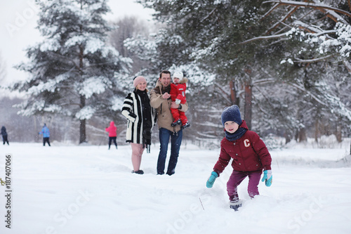 Young family with children are walking in the winter park. Winte