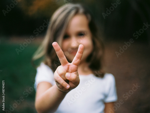 Young girl making the victory sign with her hand photo