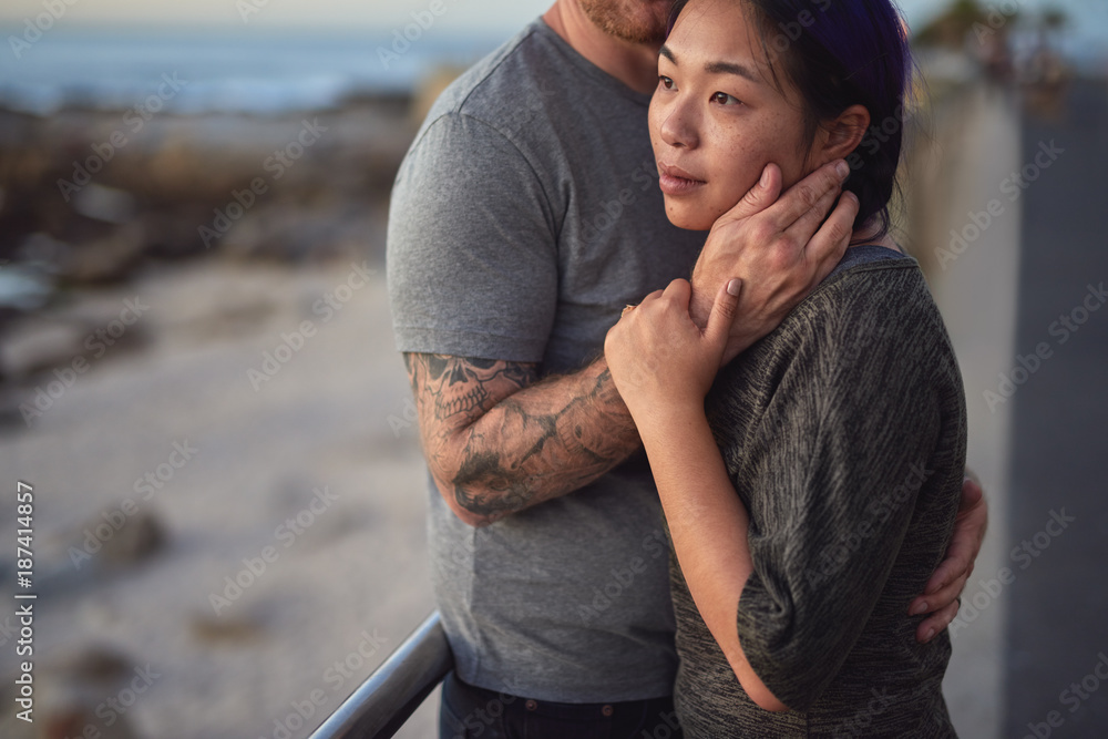 Mixed race couple hugs by the beach Mixed race couple hugs by the beach