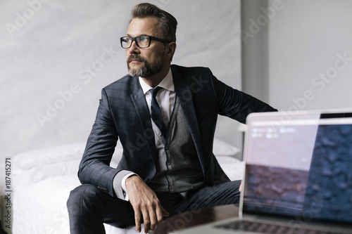 Stylish mature businessman with laptop photo