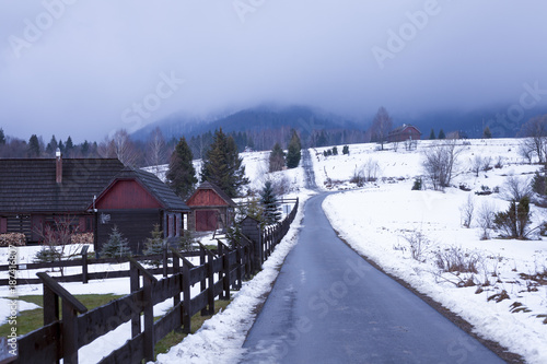 Road in Bieszczady to Wetlina and Solina, Winter day with lot of snow. Buildings in the background