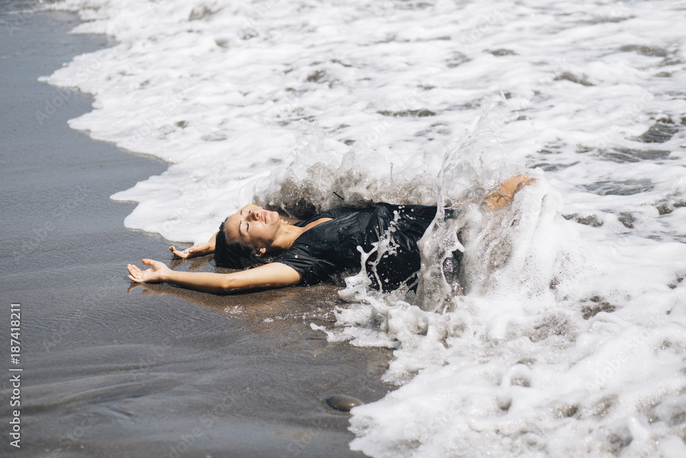Woman laying on the black sand beach Woman laying on the black sand beach