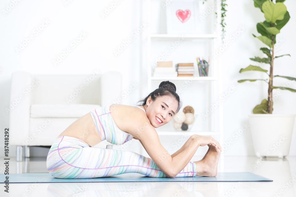 Asian beautiful sports woman performs the exercises at home . Asian beautiful sports woman performs the exercises at home .