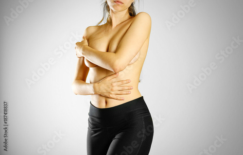 A young girl with no shirt holding hand of a sick stomach. Pain in the abdomen