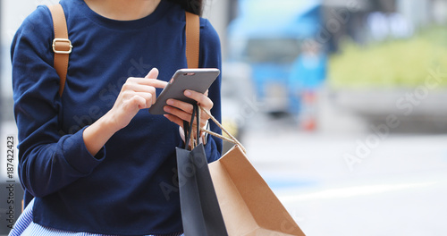 Photography Woman holding paper bag and use of mobile phone